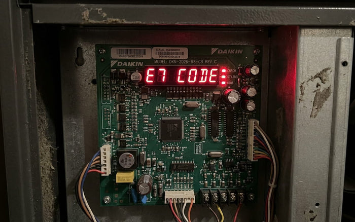 Daikin furnace control board showing an E7 error code